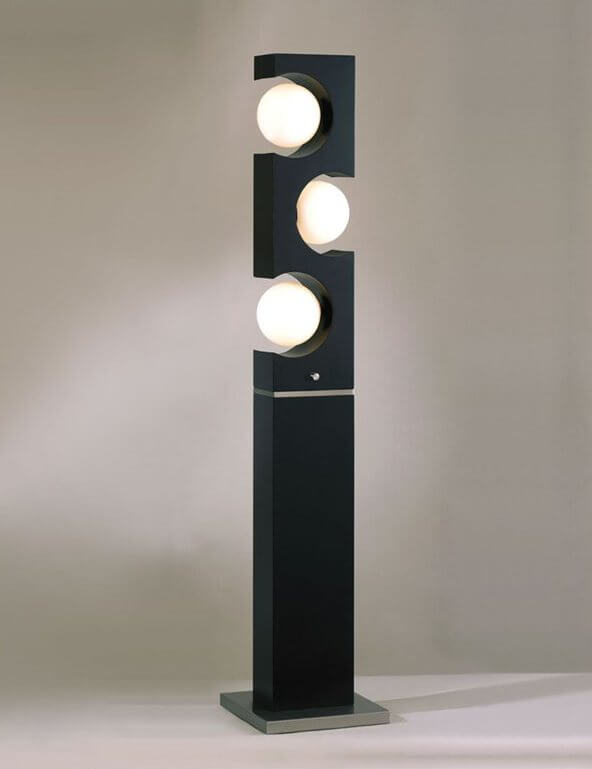 This lamp features a minimalist black slab design, with circular cutouts for 3 light spheres in the top half.