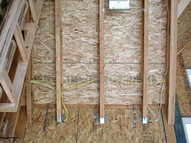 Example of SIPs used for wall and roof panels showing microlam and truss joist hanger connections and strapping, along with wiring